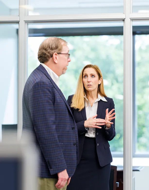 Two individuals seated on a couch in a casual office setting, appearing relaxed