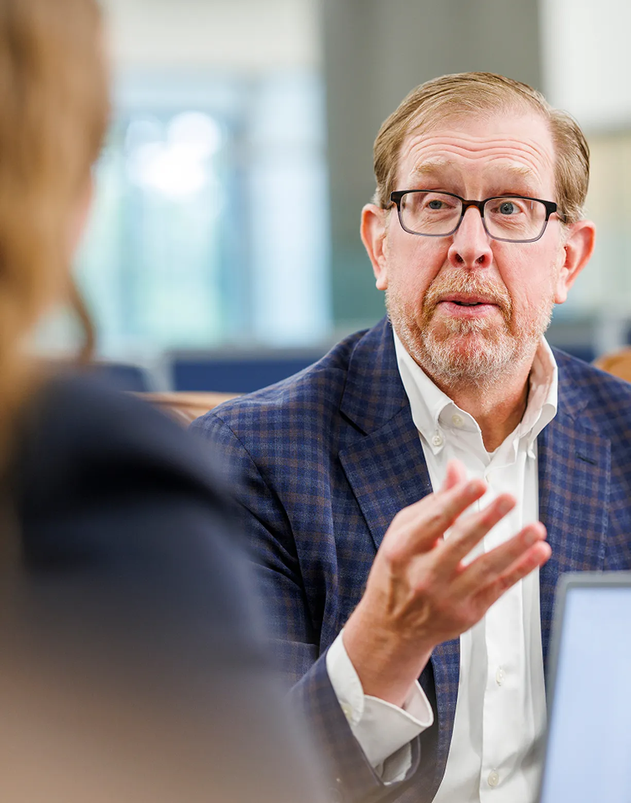 Man in a suit wearing glasses speaking during a meeting Man in a suit wearing glasses speaking during a meeting